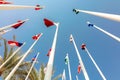 Flags of different countries of world flutters in wind background of blue sky. Bottom up view Royalty Free Stock Photo