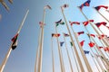 Flags of different countries of world flutters in wind background of blue sky. Bottom up view Royalty Free Stock Photo