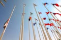 Flags of different countries of world flutters in wind background of blue sky. Bottom up view Royalty Free Stock Photo