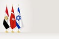 Flags of Egypt, Turkey and Israel stand in row on indoor flagpole Royalty Free Stock Photo