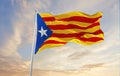 flags of Estelada blava waving in the wind on flagpoles against sky with sunset clouds on sunny day. Symbolizing patriotism. 3d Royalty Free Stock Photo