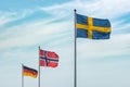 Flags of EU, Germany, Norway, Sweden on blue sky. Concepts of politics, tourism, economy, cooperation, eurozone and other