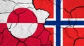 Flags of Greenland and Norway on cracked surface