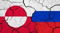 Flags of Greenland and Russia on cracked surface