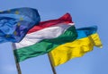 Flags of Hungary Ukraine and European Union waving on pole against blue sky Royalty Free Stock Photo