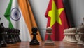 Flags of India and Vietnam behind pawns on the chessboard. Chess game or political rivalry related 3D rendering