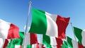 Flags of Italy against blue sky. Royalty Free Stock Photo