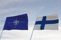 Flags of NATO and FINLAND waving with cloudy blue sky background,3D rendering WAR