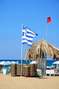 Flags and parasols on Potamos beach, Malia.