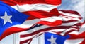 Flags of Puerto Rico waving in the wind with the United States flag on a clear day Royalty Free Stock Photo