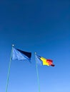Flags of Romania and European Union against clear blue sky. Vertical. Mock up copy space Royalty Free Stock Photo