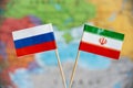 Flags of Russia and Iran over the world map, political allies, bilateral relations concept image