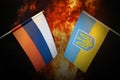 Flags of Russia and Ukraine against background of a fiery explosion. The concept of enmity and war between countries