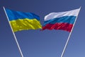 Flags of Russia and Ukraine against a blue sky. Escalation of the conflict. The concept of confrontation.