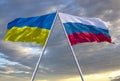 Flags of Russia and Ukraine against a dramatic cloudy sky. Escalation of the conflict. The concept of confrontation. Royalty Free Stock Photo