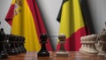 Flags of Spain and Belgium behind pawns on the chessboard. Chess game or political rivalry related 3D rendering