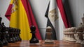 Flags of Spain and Egypt behind pawns on the chessboard. Chess game or political rivalry related 3D rendering