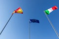 Flags of Spain, European Union and flag of Italy against the blue sky Royalty Free Stock Photo