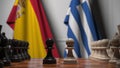 Flags of Spain and Greece behind pawns on the chessboard. Chess game or political rivalry related 3D rendering