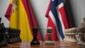 Flags of Spain and Norway behind pawns on the chessboard. Chess game or political rivalry related 3D rendering