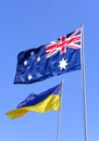 Flags of Ukraine and Australia are flying against the blue sky Royalty Free Stock Photo