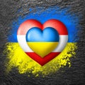 Flags of Ukraine and Austria. Two hearts in the colors of the flags on the flag of Ukraine painted on stone. Protection,