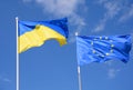 Flags of Ukraine and European Union EU against the blue sky. Royalty Free Stock Photo