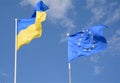 Flags of Ukraine and European Union EU against the blue sky. Royalty Free Stock Photo