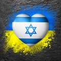 Flags of Ukraine and Israel. Flag heart on the background of the flag of Ukraine painted on a stone. The concept of protection.