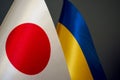 Flags of Ukraine and Japan on a dark background