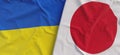 Flags of Ukraine and Japan. Linen flag close up. Flag made of canvas. Ukrainian, Kyiv. Japanese, Tokyo. National symbols. 3d