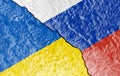 The flags of Ukraine and Russia painted on a ruined wall and divided by a diagonal crack