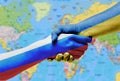 The flags of Ukraine and Russia shake hands on the background of the world map.