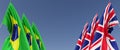 Flags of the United Kingdom and Brazil on flagpoles on sides. Six flags on a blue background. Place for text. Great Britain,