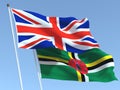 The flags of United Kingdom and Dominica on the blue sky. For news, reportage, business. 3d illustration