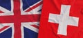 Flags of United Kingdom and Switzerland. Linen flags close-up. Flag made of canvas. British, Great Britain. Swiss. National