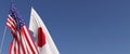 Flags of the USA and Japan on flagpoles on side. Flags on a blue background. Place for text. United States of America. Tokyo, Asia Royalty Free Stock Photo