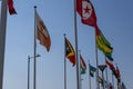 Flags waving in the wind on flagpoles equal distant apart against a blue sky Royalty Free Stock Photo