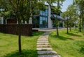 Flagstone path in lawn to two-storied modern building on sunny s
