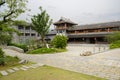 Flagstone path before tile-roofed buildings in cloudy afternoon