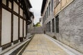 Flagstone alley between old-fashioned buildings in cloudy afternoon Royalty Free Stock Photo