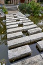 A flagstone recreational walkway over a pond in a traditional Chinese garden Royalty Free Stock Photo