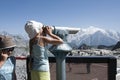 Cute little braided haired girl look Mont Blanc with binoculars