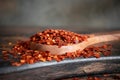 Flakes of red hot chili pepper in wooden spoon closeup on a kitchen table Royalty Free Stock Photo