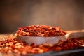 Flakes of red hot chili pepper in wooden spoon closeup on a kitchen table Royalty Free Stock Photo