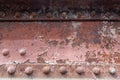 Flaking paint on a rusty riveted bridge