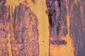 The flaking yellow color with scratched on the surface of rusty galvanized iron plate. Rusty yellow painted metal wall. Rusty meta