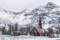 Flakstad church, a beautiful red wooden church in snowy mountains Royalty Free Stock Photo