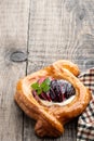 Flaky pastry with plum on wooden table