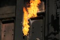 Flame from burning gas leak on coke oven door seal.